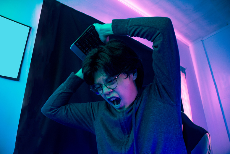 Angry Male Gamer Smashing Keyboard
